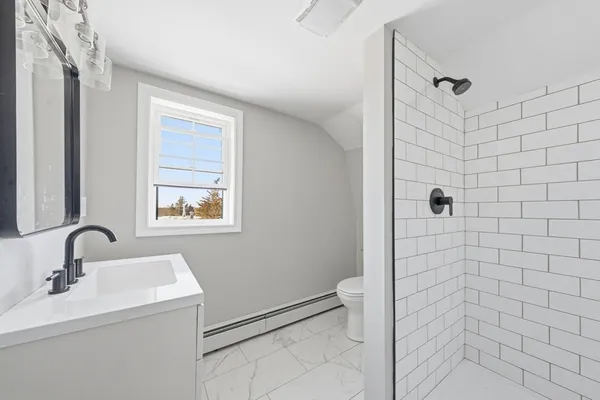 a bathroom with a sink a toilet and shower