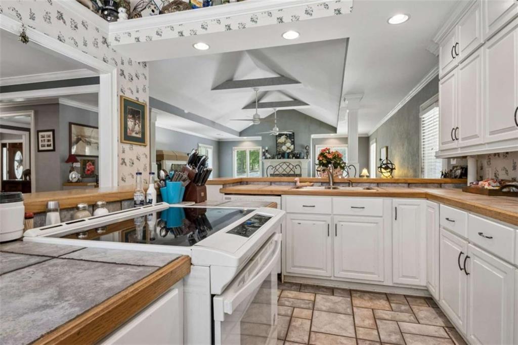 4751 Bill Cheek Road Auburn, GA 30011 - Photo 27 of 82 a kitchen with a sink dishwasher and white cabinets with wooden floor
