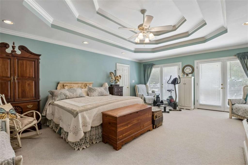 4751 Bill Cheek Road Auburn, GA 30011 - Photo 31 of 82 a spacious bedroom with a bed gym equipment and a large mirror