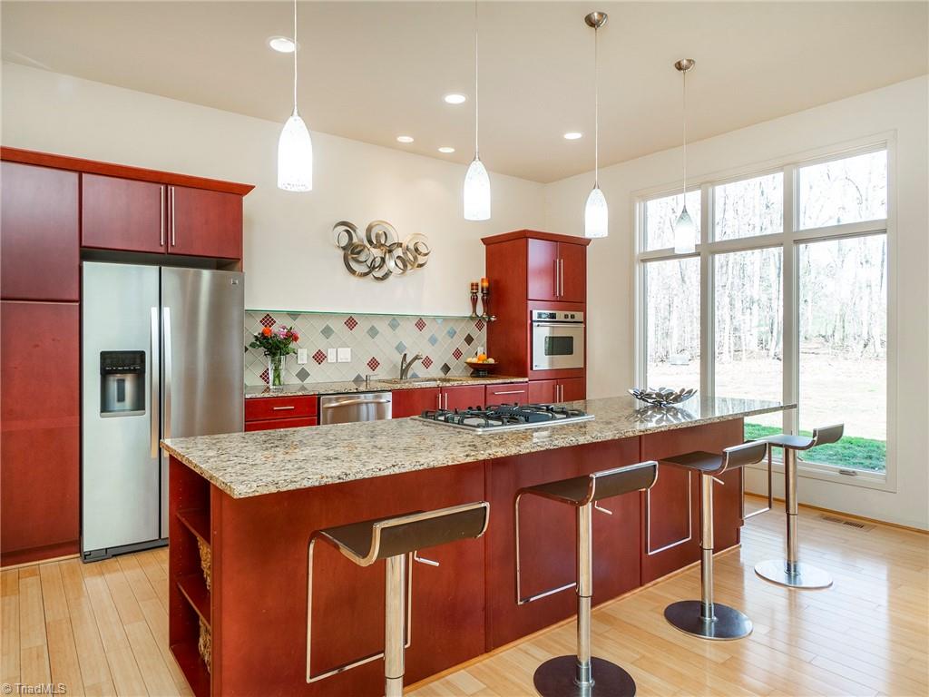 725 Hudson Road Summerfield, NC 27358 - Photo 12 of 36 Gorgeous custom kitchen with natural light and views of the private backyard.