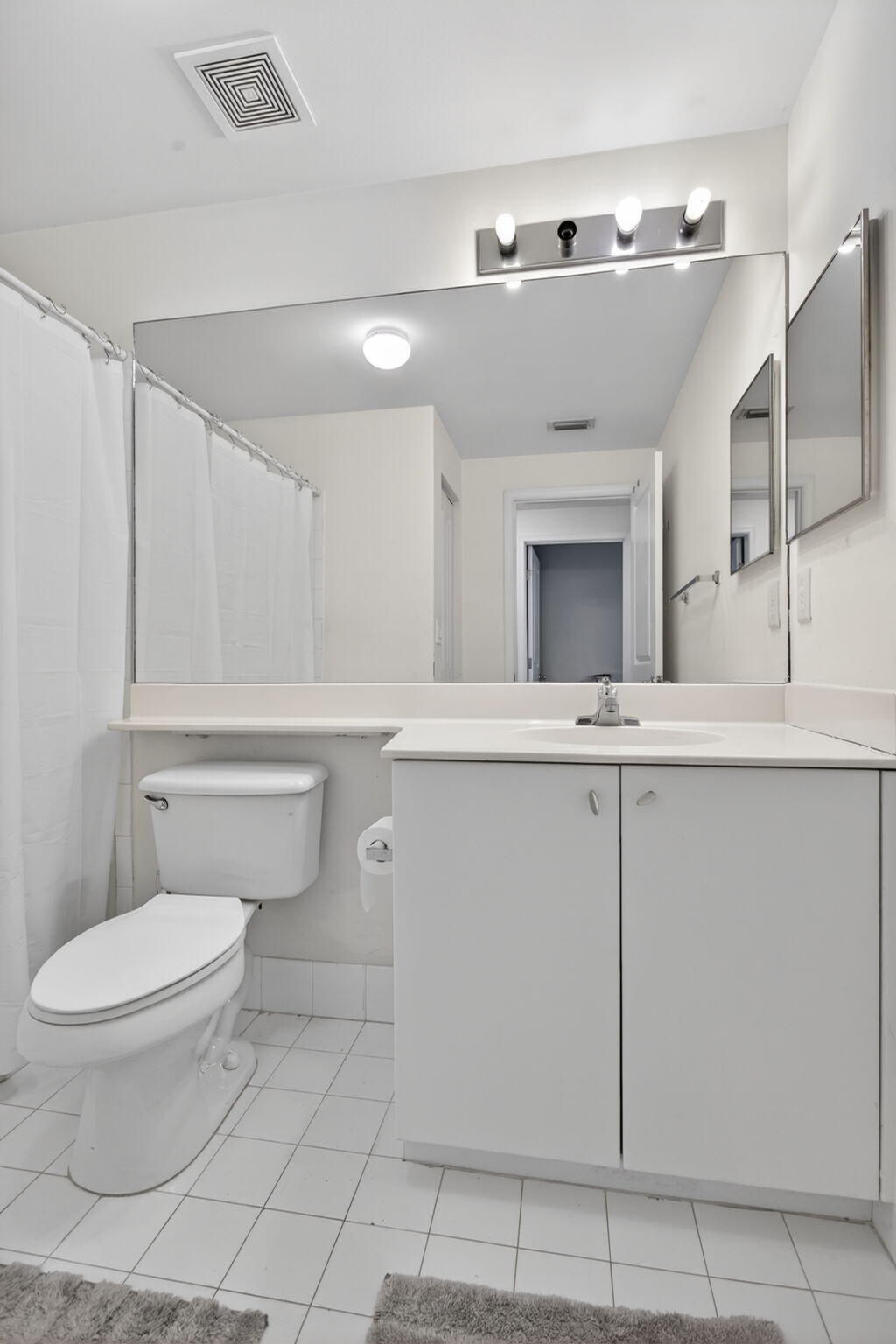 5880 West Sample Road, Unit 206 Coral Springs, FL 33067 - Photo 15 of 37 a bathroom with a toilet sink and mirror