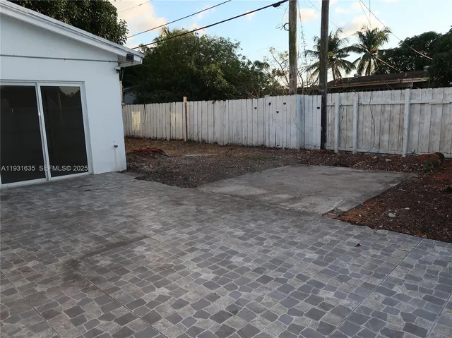 a view of backyard with wooden fence
