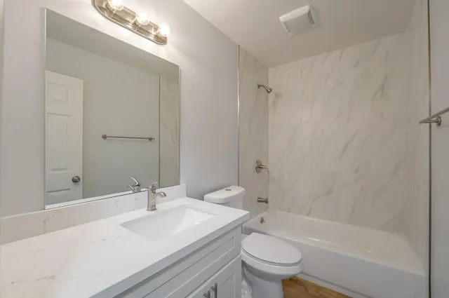a view of an empty room with wooden floor and closet