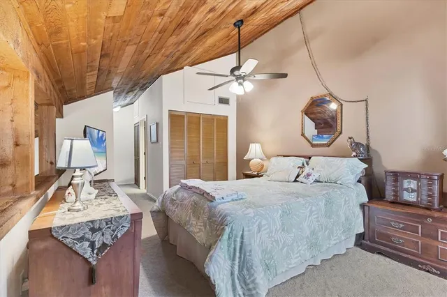 a bedroom with a bed dresser and wooden floor