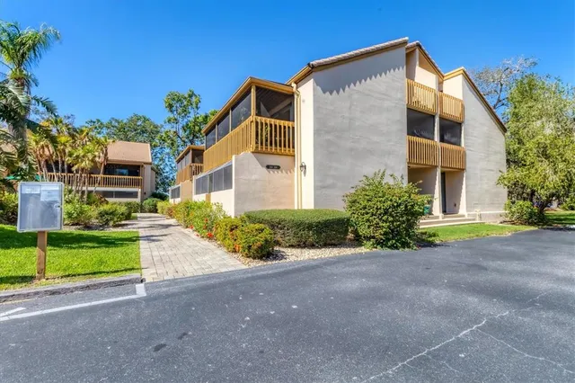 a view of a house with a yard and table and chairs under an umbrella