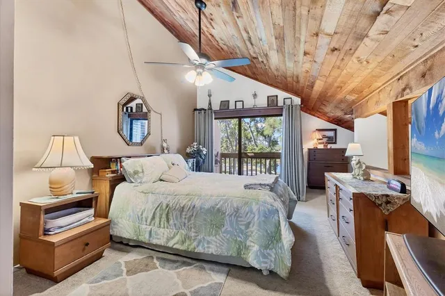 a bedroom with a bed a flat screen tv and a large window with the outer view