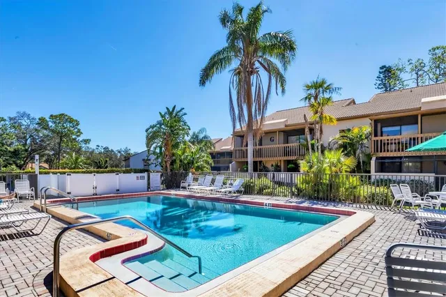 a view of a swimming pool with a patio and a yard