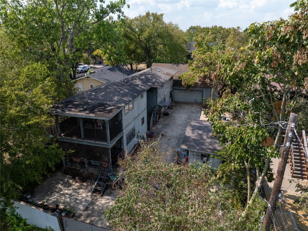 View of subject property featuring a tree filled landscape