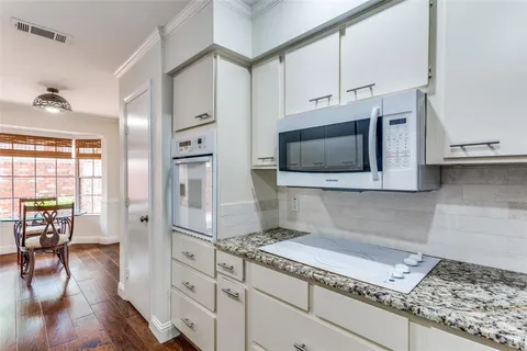 a kitchen with stainless steel appliances granite countertop a stove microwave and cabinets