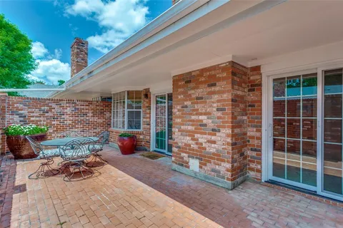 a view of a patio with table and chairs and potted plants