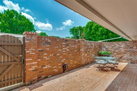 a view of a patio with table and chairs with wooden floor and fence