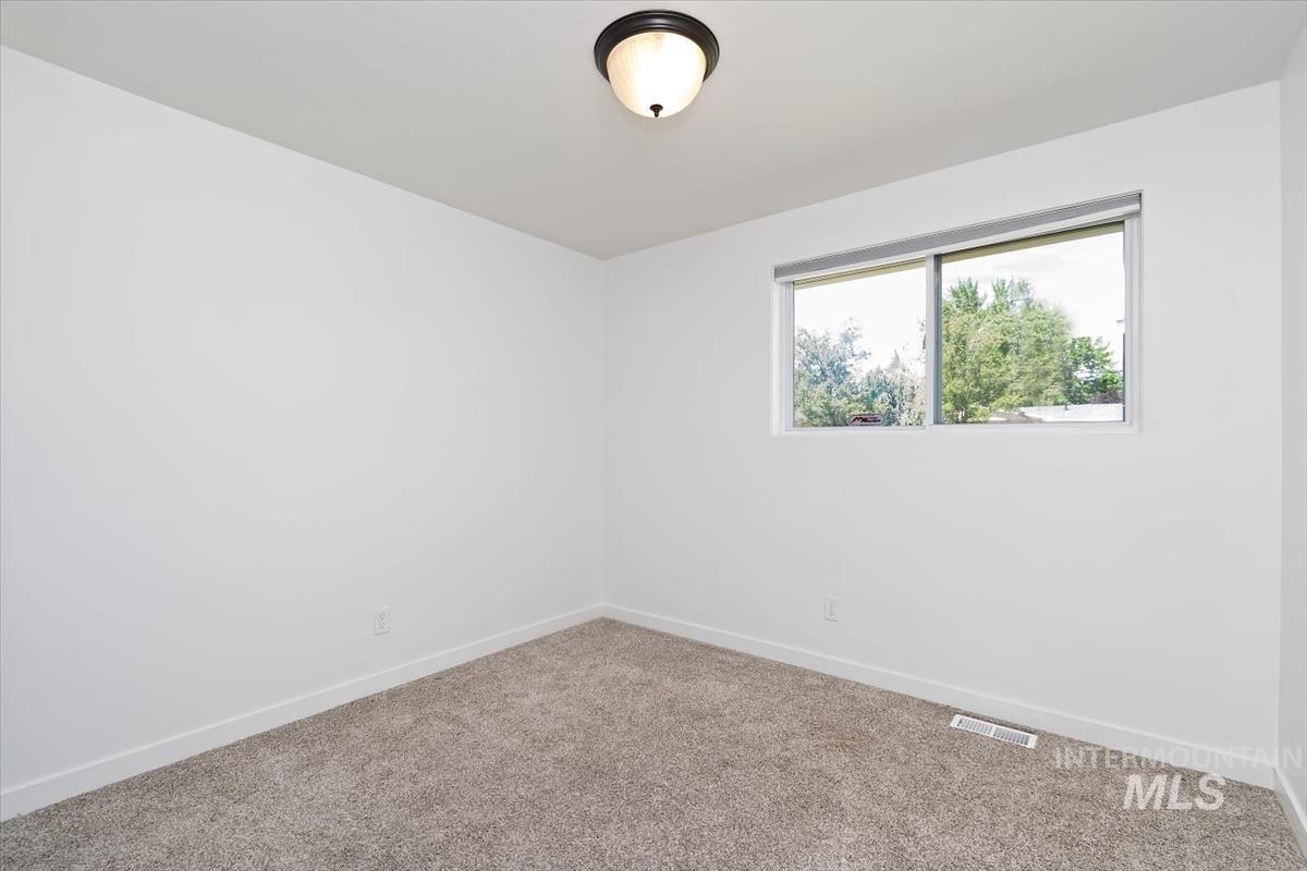2217 North Middlefield Road Boise, ID 83704 - Photo 29 of 34 Carpeted room featuring a single horizontal window, a flush-mount ceiling light, white walls, and white baseboards