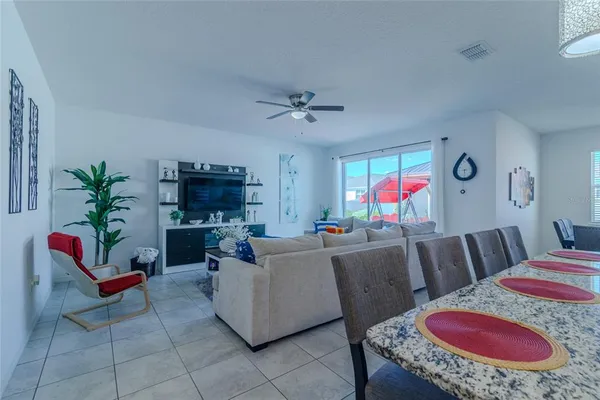 a living room with furniture a flat screen tv and a dining table