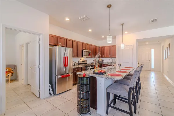 a kitchen with stainless steel appliances granite countertop a sink refrigerator and cabinets