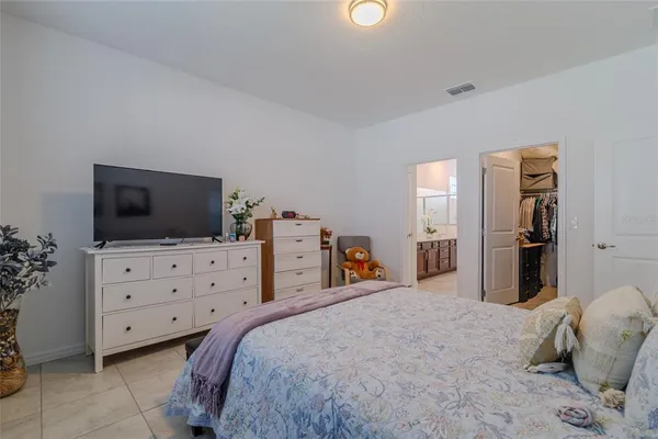 a bedroom with a bed and painting on the wall