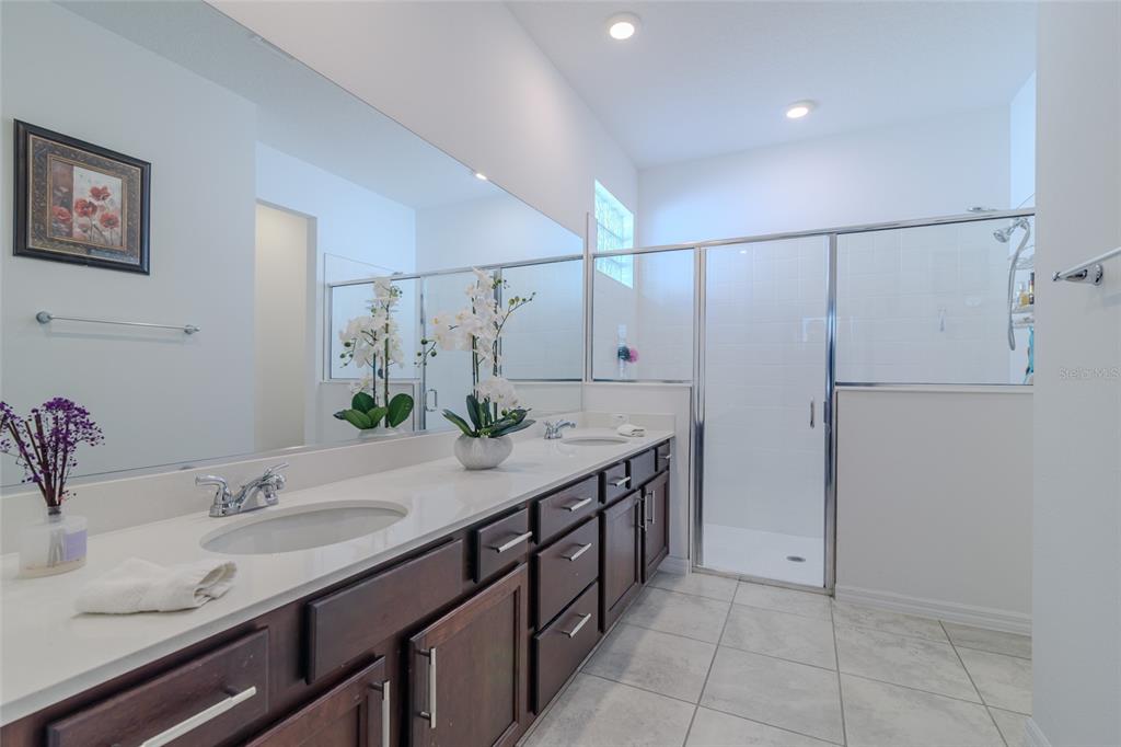 7095 Southwest 61st Place Ocala, FL 34474 - Photo 32 of 61 a spacious bathroom with a granite countertop sink a mirror and a shower