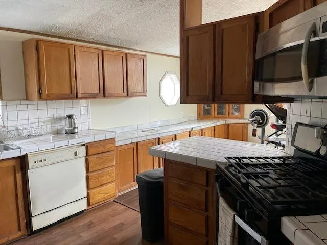 a kitchen with a refrigerator sink and wooden cabinets