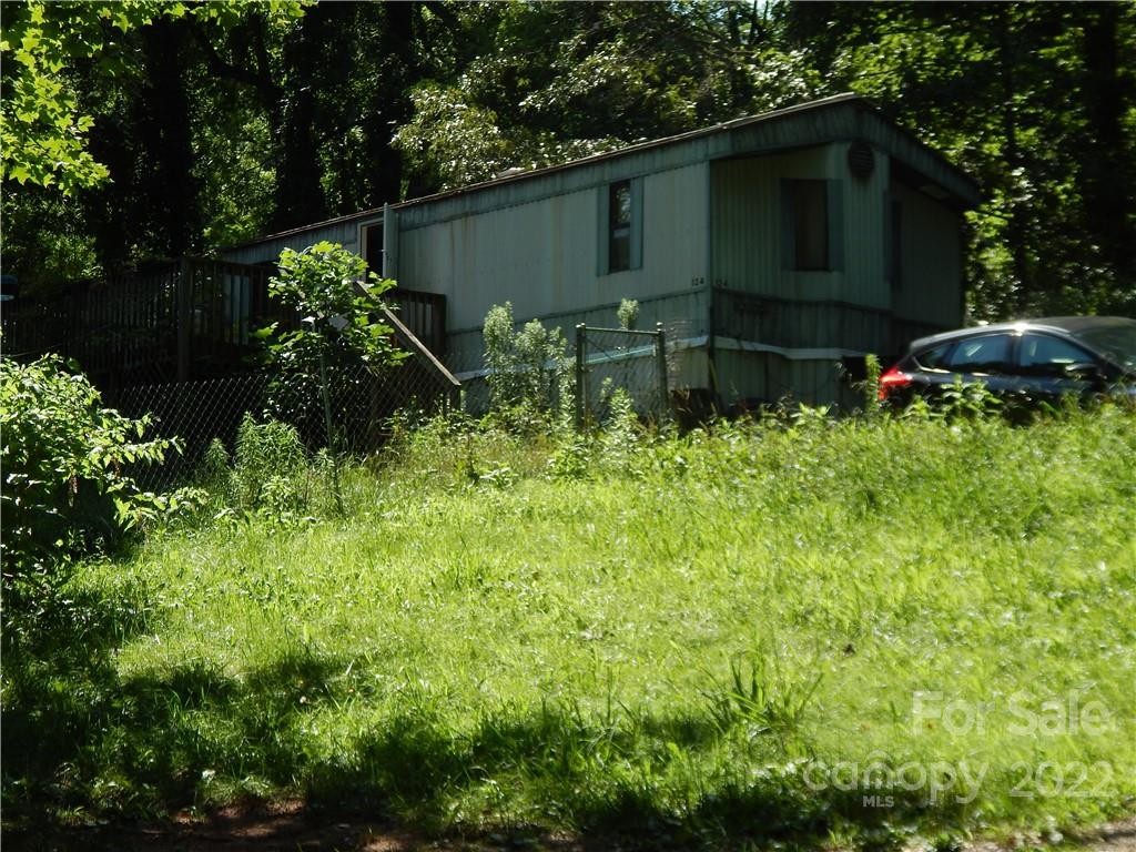 124 Oconeechee Road Clyde, NC 28721 - Photo 13 of 14 a backyard of a house with lots of green space and plants