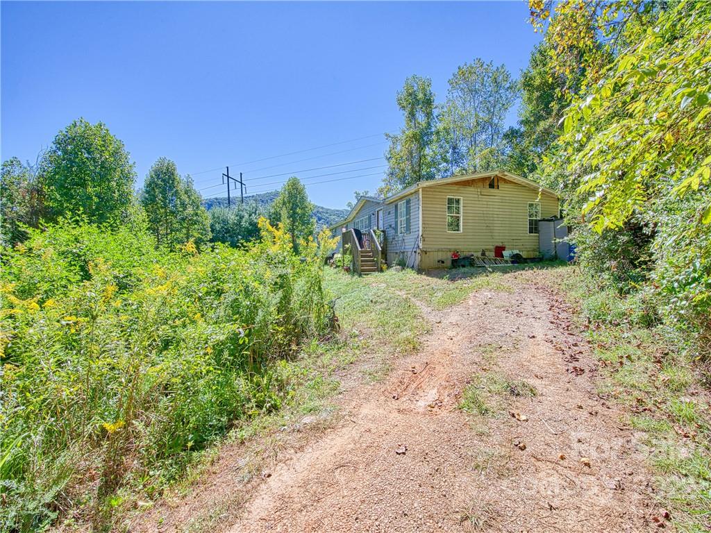 124 Oconeechee Road Clyde, NC 28721 - Photo 5 of 14 a yellow house with trees in the background