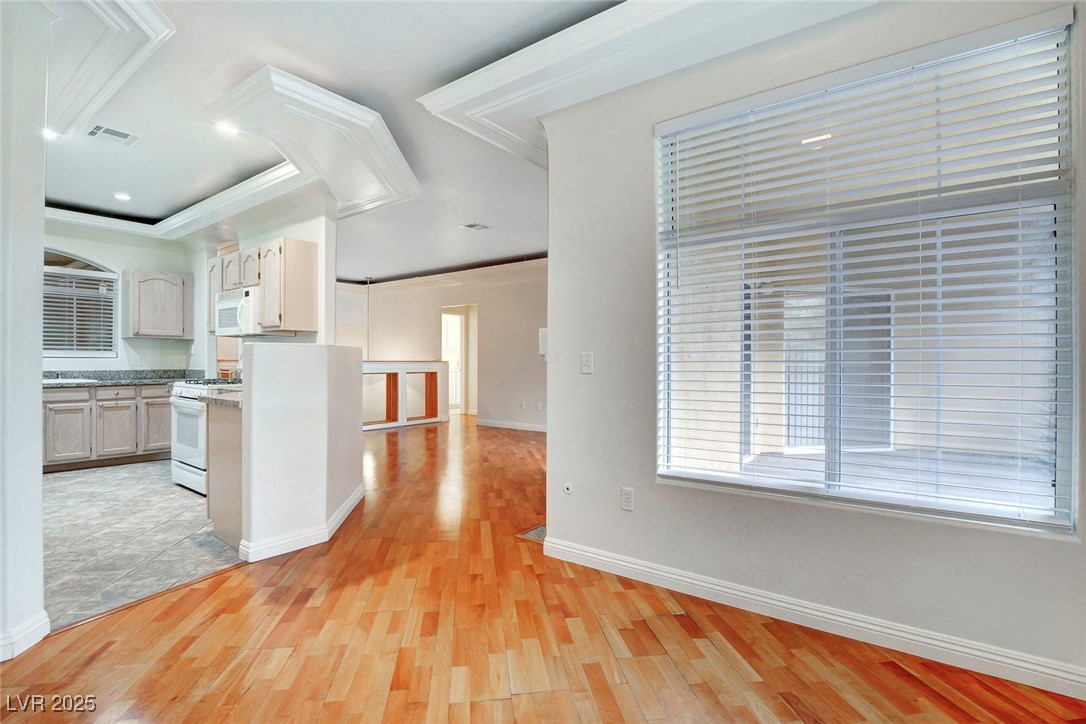 8725 Red Rio Drive, Unit 203 Las Vegas, NV 89128 - Photo 15 of 38 Kitchen with white appliances, ornamental molding, light wood-type flooring, and baseboards