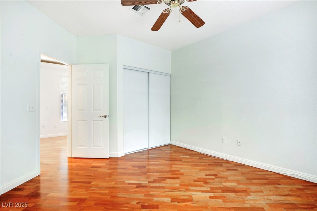 8725 Red Rio Drive, Unit 203 Las Vegas, NV 89128 - Photo 18 of 38 Unfurnished bedroom with light wood-style floors, baseboards, a closet, and ceiling fan