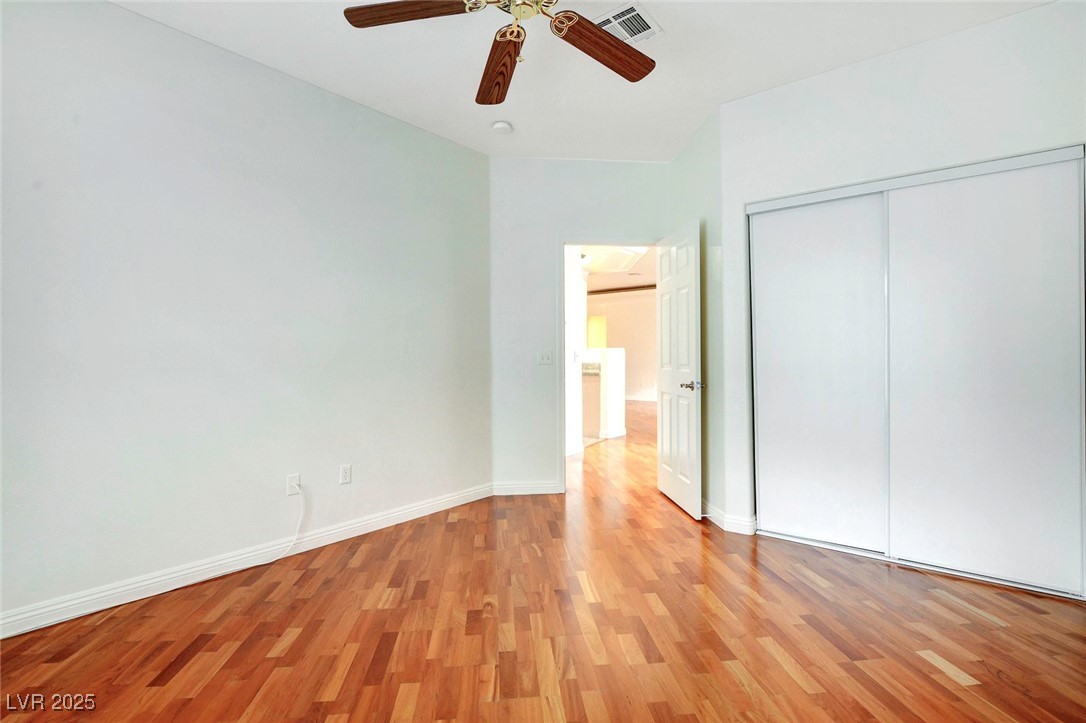 8725 Red Rio Drive, Unit 203 Las Vegas, NV 89128 - Photo 19 of 38 Unfurnished bedroom featuring light wood finished floors, baseboards, a closet, and ceiling fan