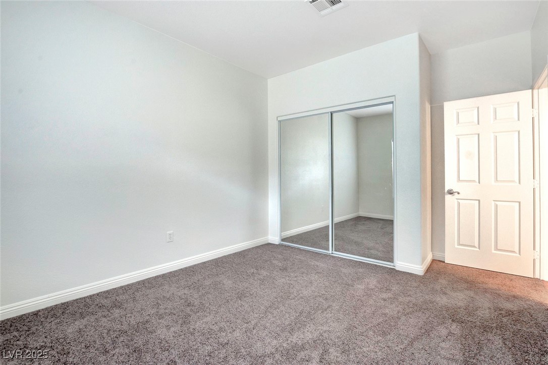 8725 Red Rio Drive, Unit 203 Las Vegas, NV 89128 - Photo 21 of 38 Unfurnished bedroom with carpet flooring, a closet, and baseboards