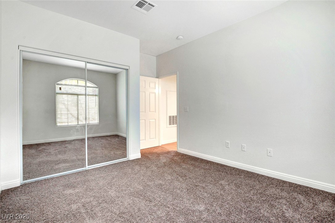 8725 Red Rio Drive, Unit 203 Las Vegas, NV 89128 - Photo 22 of 38 Unfurnished bedroom with carpet floors, a closet, and baseboards