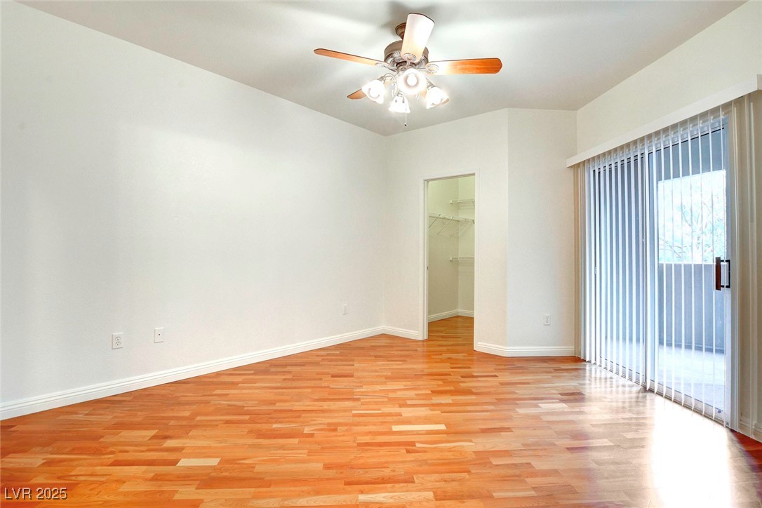 8725 Red Rio Drive, Unit 203 Las Vegas, NV 89128 - Photo 24 of 38 Spare room with light wood-style floors, a ceiling fan, and baseboards
