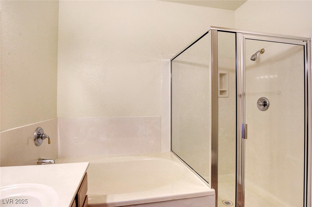 8725 Red Rio Drive, Unit 203 Las Vegas, NV 89128 - Photo 29 of 38 Full bathroom featuring a shower stall, a bath, and vanity