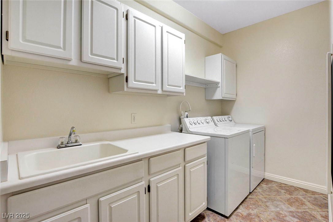 8725 Red Rio Drive, Unit 203 Las Vegas, NV 89128 - Photo 30 of 38 Laundry area with cabinet space, washing machine and clothes dryer, and baseboards