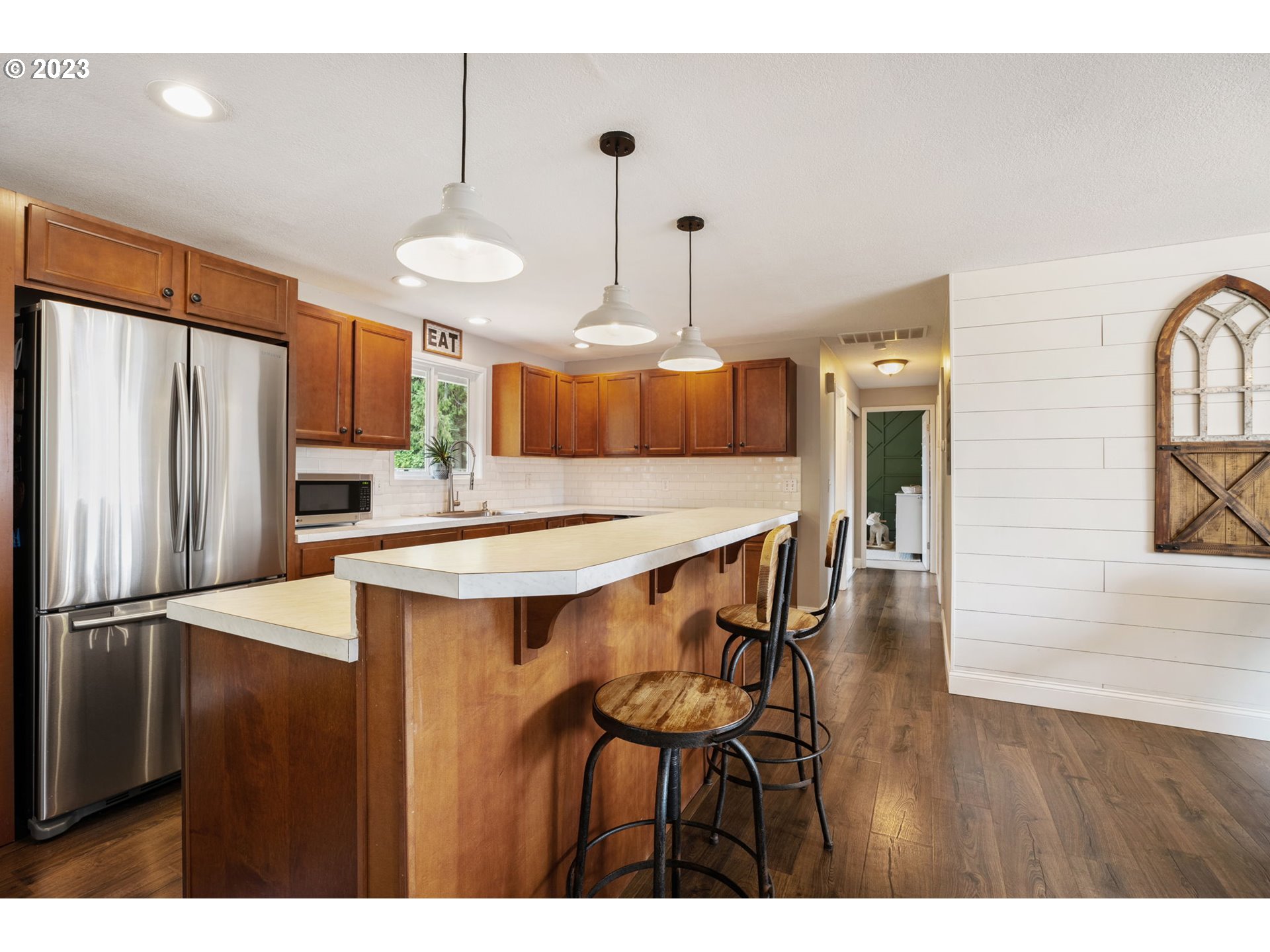 326 Southeast 236th Court Gresham, OR 97030 - Photo 6 of 34 a kitchen with stainless steel appliances a dining table chairs and wooden floor