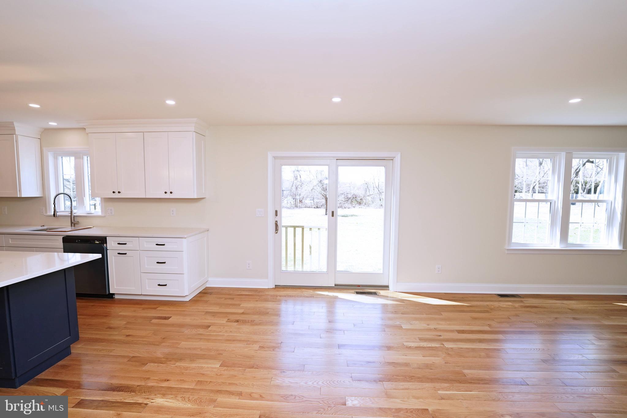 1341 Lower Ferry Road Ewing, NJ 08618 - Photo 12 of 39 a large white kitchen with kitchen island a sink wooden floor and a window