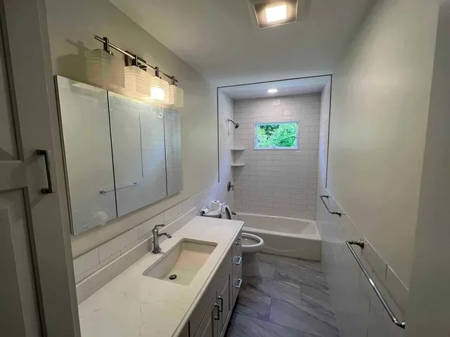 a bathroom with a sink a toilet and shower