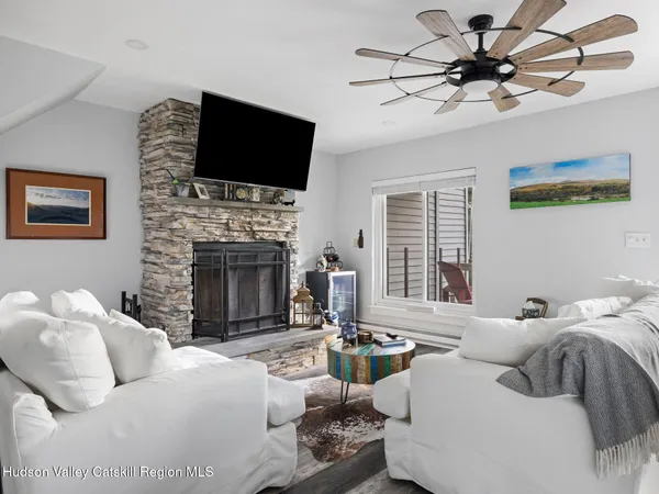 a living room with furniture a fireplace and a flat screen tv