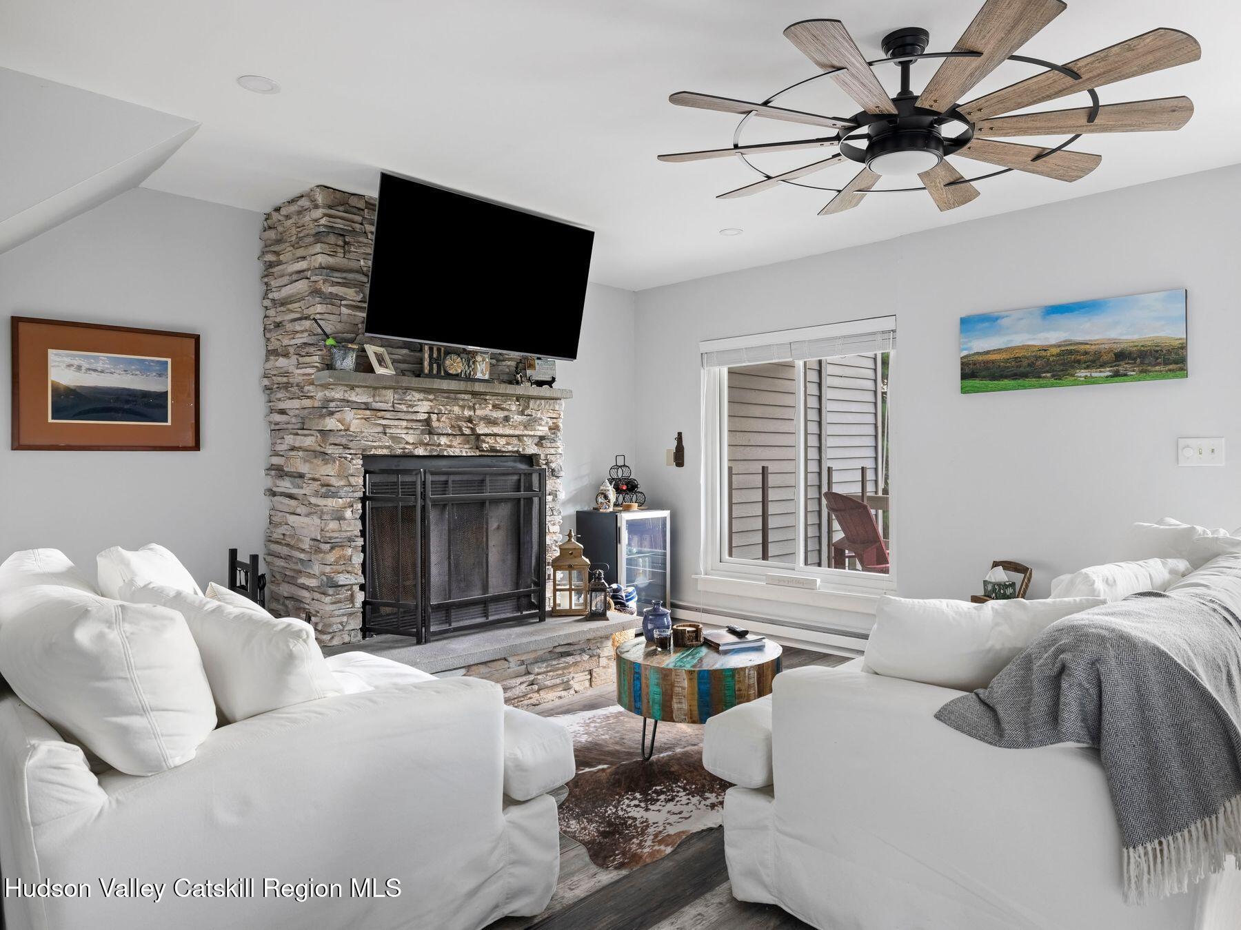 73 Windham Ridge Road, Unit 16H Windham, NY 12496 - Photo 2 of 36 a living room with furniture a fireplace and a flat screen tv