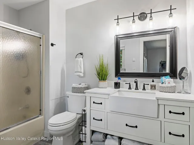a bathroom with a toilet sink vanity and shower