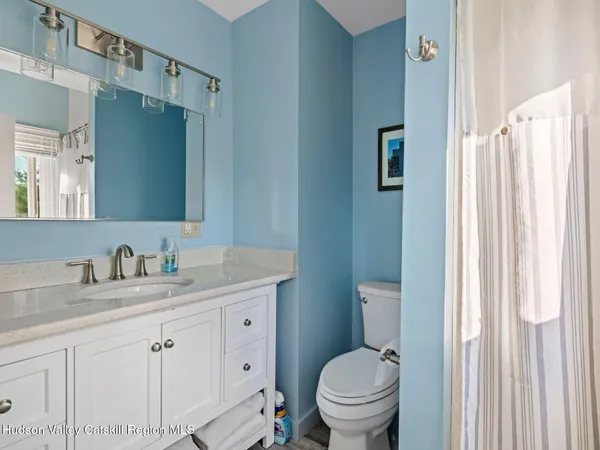 a bathroom with a granite countertop sink toilet and a mirror