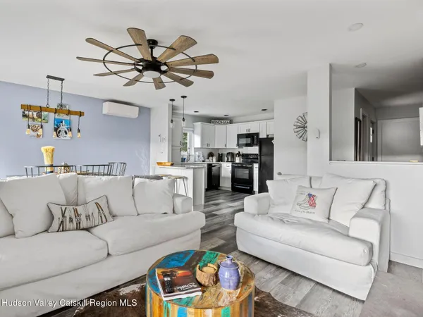 a living room with furniture kitchen view and a chandelier