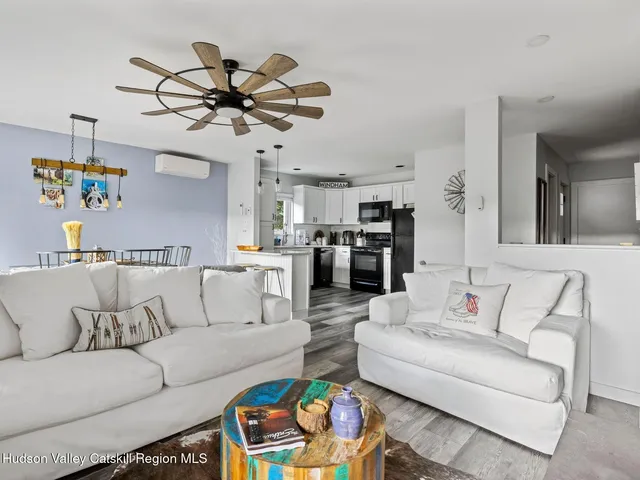 a living room with furniture kitchen view and a chandelier