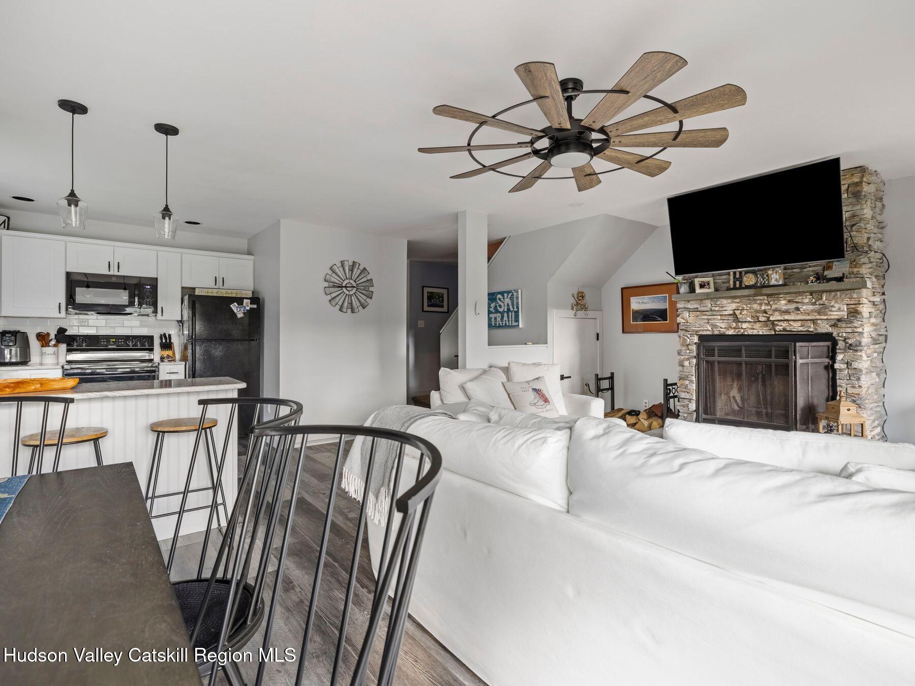 73 Windham Ridge Road, Unit 16H Windham, NY 12496 - Photo 6 of 36 a view of a livingroom with furniture a flat screen tv and a fireplace