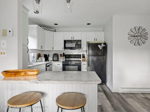 a kitchen with stainless steel appliances granite countertop a sink a stove a refrigerator a washer and dryer