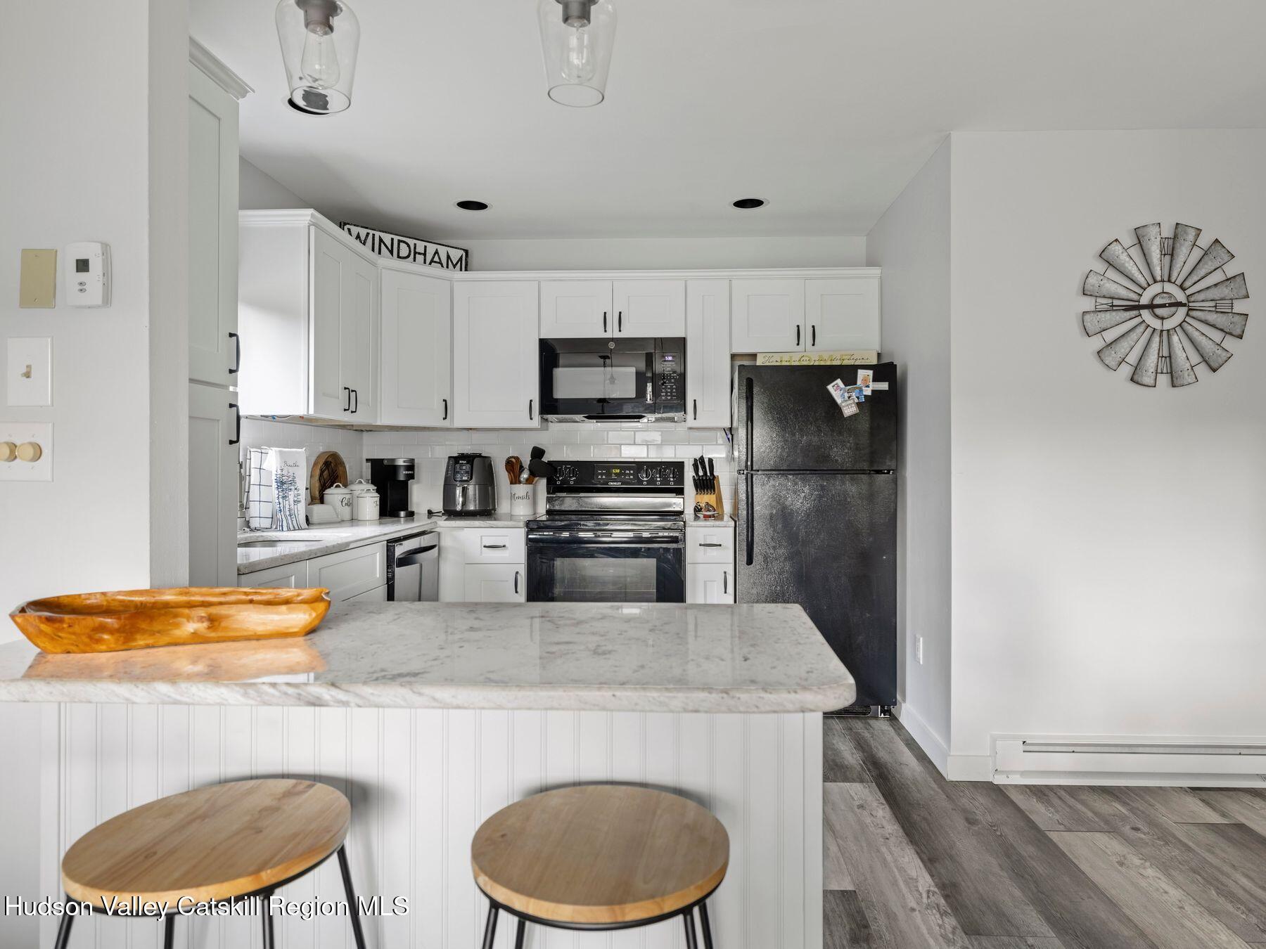73 Windham Ridge Road, Unit 16H Windham, NY 12496 - Photo 7 of 36 a kitchen with stainless steel appliances granite countertop a sink a stove a refrigerator a washer and dryer
