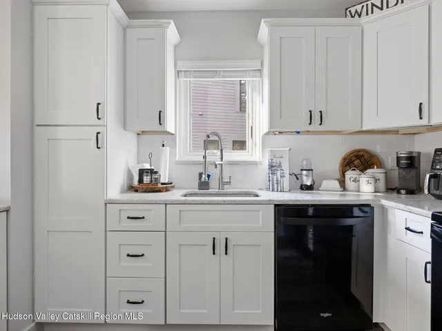 a kitchen with cabinets appliances a sink and a window