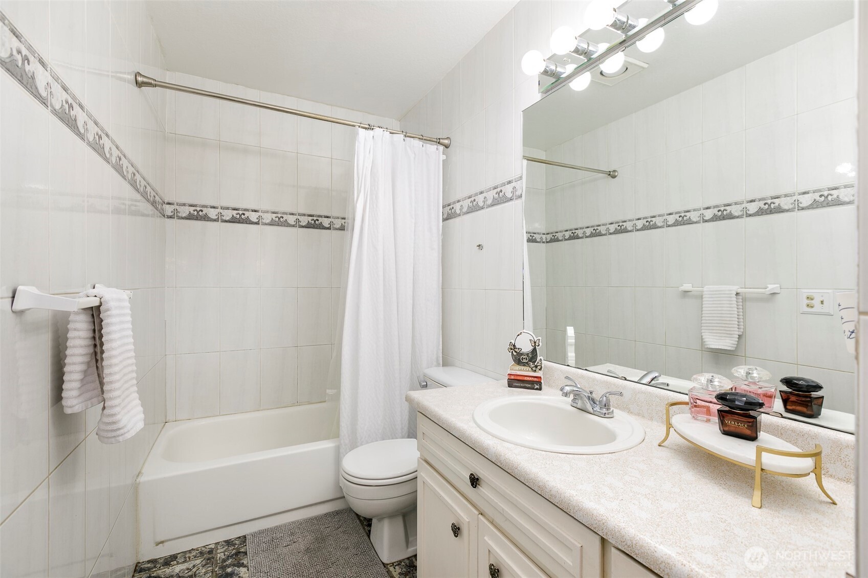4003 Northeast 6th Court Renton, WA 98056 - Photo 12 of 20 a bathroom with a sink a toilet a mirror a bathtub and shower