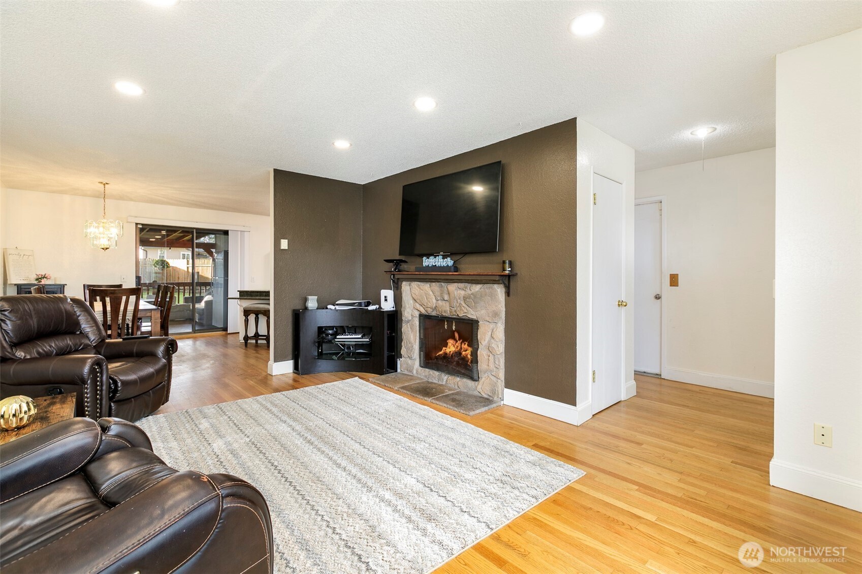 4003 Northeast 6th Court Renton, WA 98056 - Photo 5 of 20 a bed room with a flat screen tv and a fireplace