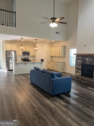 a living room with couches and kitchen view with wooden floor