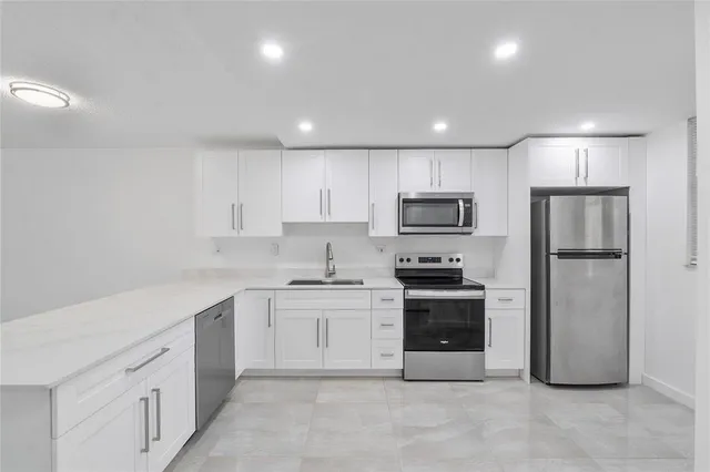 a large kitchen with stainless steel appliances granite countertop a stove a sink and a refrigerator