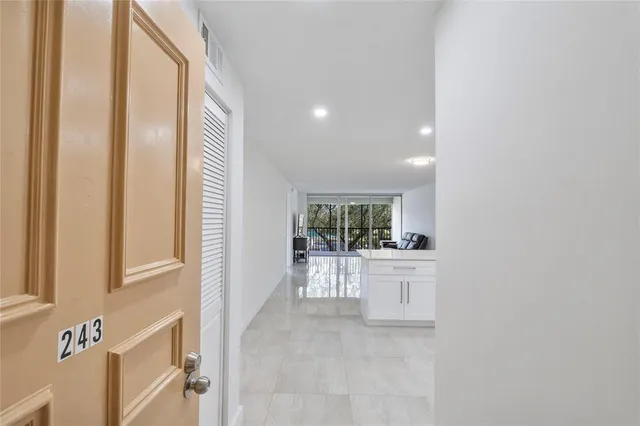 a view of a kitchen with a sink and dishwasher a refrigerator with white cabinets