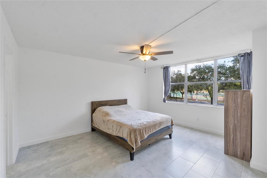 3751 Environ Boulevard, Unit 243 Lauderhill, FL 33319 - Photo 13 of 24 a room with a bed and a chandelier